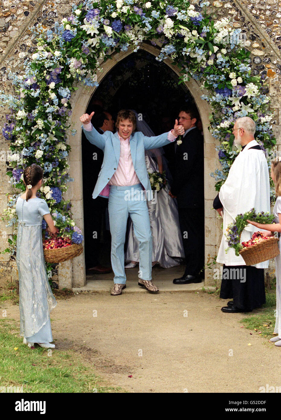 Der berühmte Fernsehkoch Jamie Oliver (in einem blauen Paul Smith-Anzug) gibt das Daumen-hoch-Zeichen, nachdem er seine Braut Juliette Norton (Jools) in der All Saints Church in Rickling in Essex geheiratet hat. Das glückliche Paar, beide 25, kennen sich seit über einem Jahrzehnt. * ...und jetzt sind sowohl ihr persönliches als auch ihr berufliches Leben miteinander verbunden, da Jools als Jamie's PA arbeitet. Stockfoto