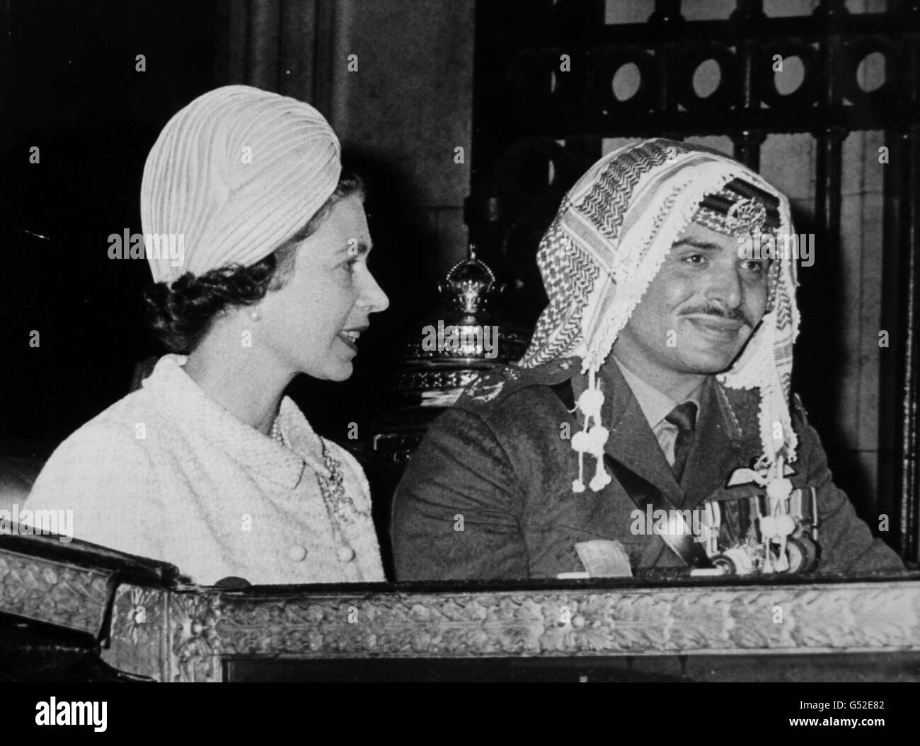 Königin Elizabeth II. Und König Hussein von Jordanien kommen am Buckingham Palace an, nachdem sie in einem offenen Wagen vom Bahnhof Victoria aus durch das regnerisch durchnässte London gefahren sind. Stockfoto