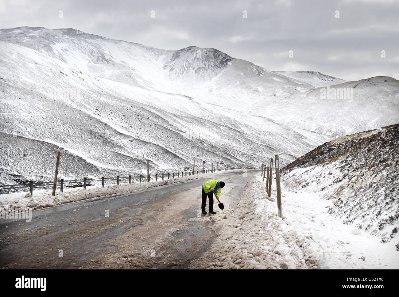 Ein ratsarbeiter aus Perth und der Kinross-Rat fahren an der mit Eis bedeckten A93 am Spittal von Glenshee in den Cairngorms ab, nachdem sie gestern wegen Schneefalls geschlossen war. Stockfoto