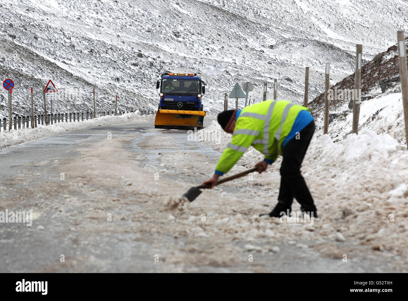 Ein ratsarbeiter und Grinter aus Perth und der Kinross-Rat schnapp sich an der Eis bedeckten A93 am Spittal von Glenshee in den Cairngorms ab, nachdem sie gestern wegen Schneefalls geschlossen war. Stockfoto