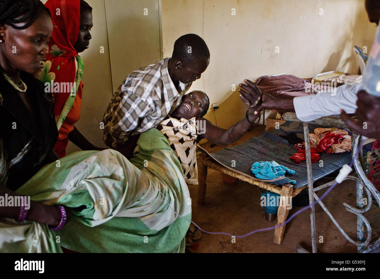 Verletzte Flüchtlinge und Soldaten in der gemeinsamen Klinik in Bunj, Maban, im Bundesstaat Upper Nile Blue Nile im Nordosten des Südsudans, Afrika. Die Region litt vor kurzem unter schweren Zusammenstößen zwischen Nord- und Südsudan, die Zehntausende von Menschen in Flüchtlingslager wie Doro und JamMan zwangen und Hunderte von Todesfällen durch die Bombardierung von Dörfern und Zusammenstöße zwischen rivalisierenden bewaffneten Gruppen zur Folge hatten. Stockfoto