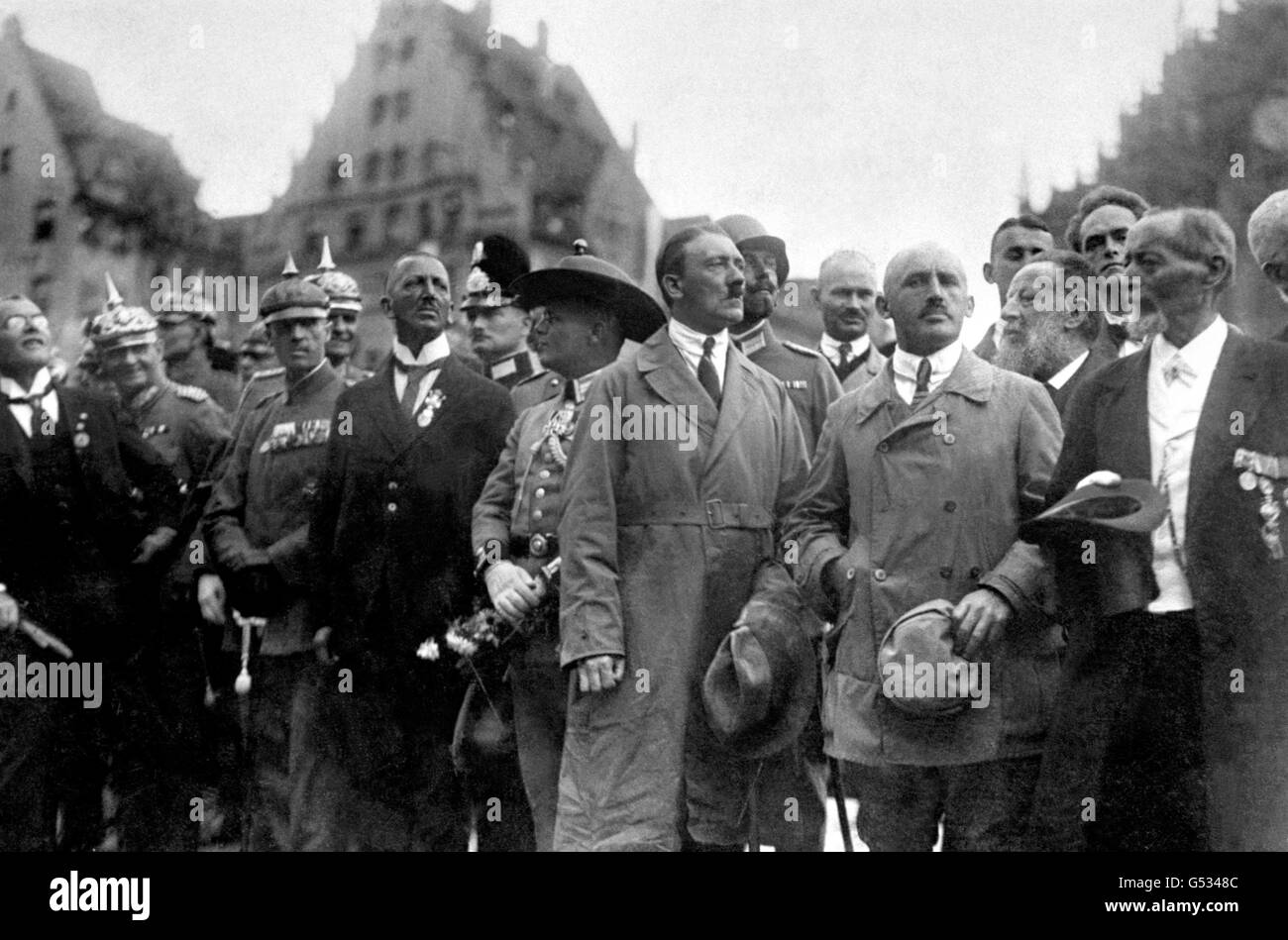 ADOLF HITLER 1923 (c, in Trenchcoat), Führer der NSDAP, und Julius Streicher (links Hitlers, kahl), Herausgeber von 'der Sturmer', beobachten einen marsch nationalistischer Anhänger am 'Deutschen Tag' in Nürnberg, Bayern. Schätzungsweise 100,000 Personen haben an der Veranstaltung teilgenommen. *mit ihnen sind Würdenträger und Offiziere der kaiserlichen Armee aus der Kaiserzeit. Stockfoto