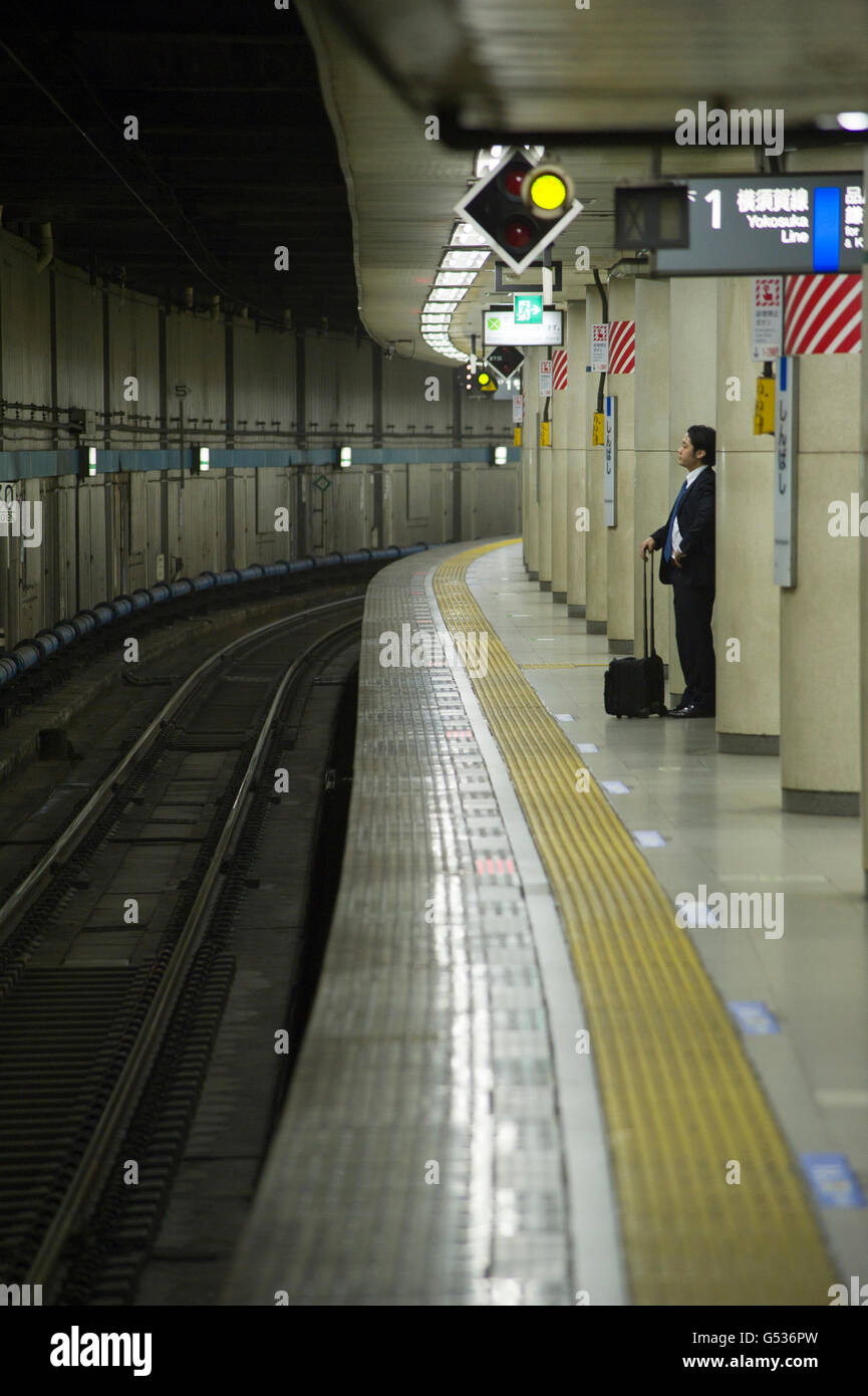 Bürokauffrau, warten auf ein JR-Zug auf einer Plattform in Tokio Stockfoto