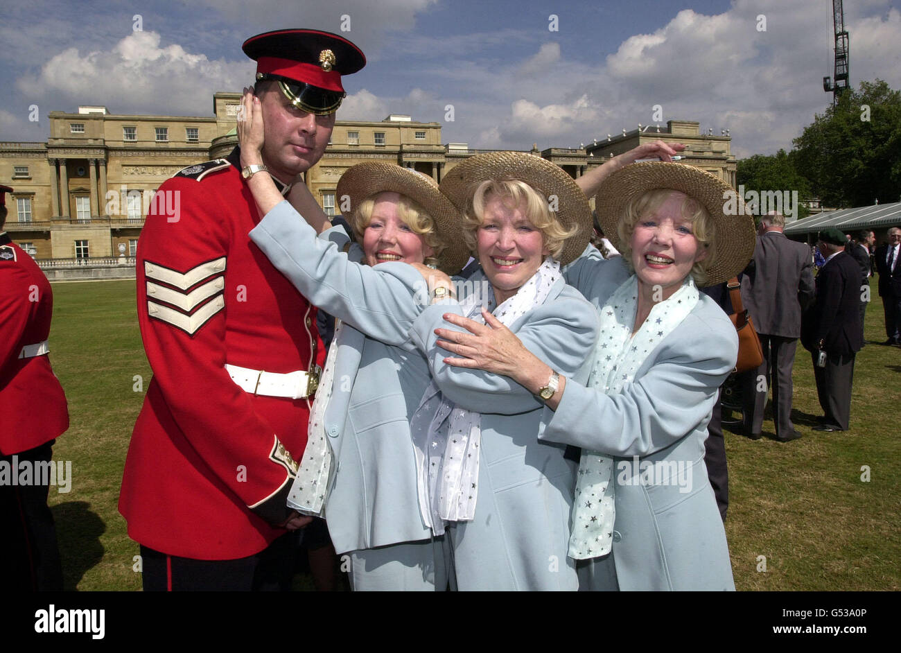 Veteran Singing Group The Beverley Sisters (L-R, Babs, Joyce und Teddie) mit einem Grenadier Guardsman auf der Not Forgotten Garden Party, die von der Prinzessin Royal besucht wird, auf dem Gelände des Buckingham Palace. Stockfoto