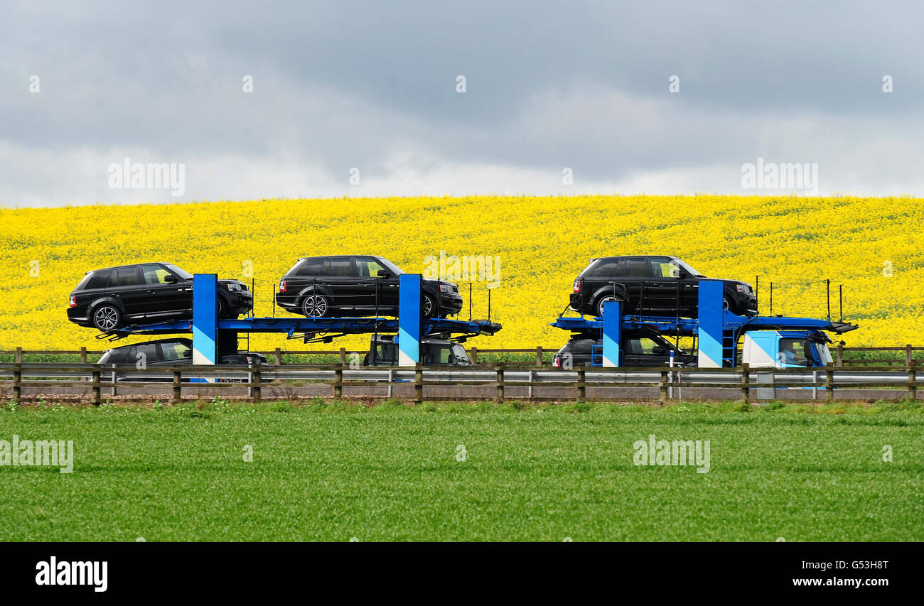 LKW-Bestand. Allgemeine Ansicht von Landrovern auf einem Transportfahrzeug auf der Autobahn M42. Stockfoto