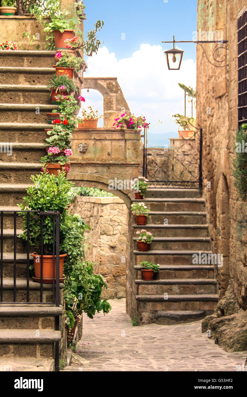 Schöne Gasse mit Blumen und Treppe in einem kleinen Dorf Stockfoto