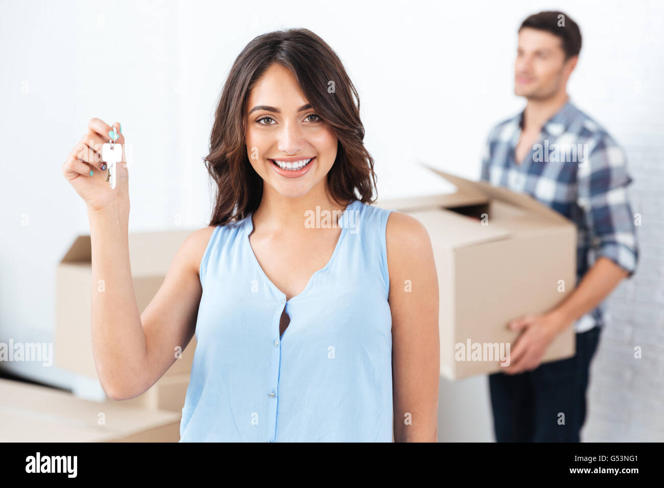 Happy Ehepaar mit Schlüssel und Kartons Umzug in neues Zuhause Stockfoto