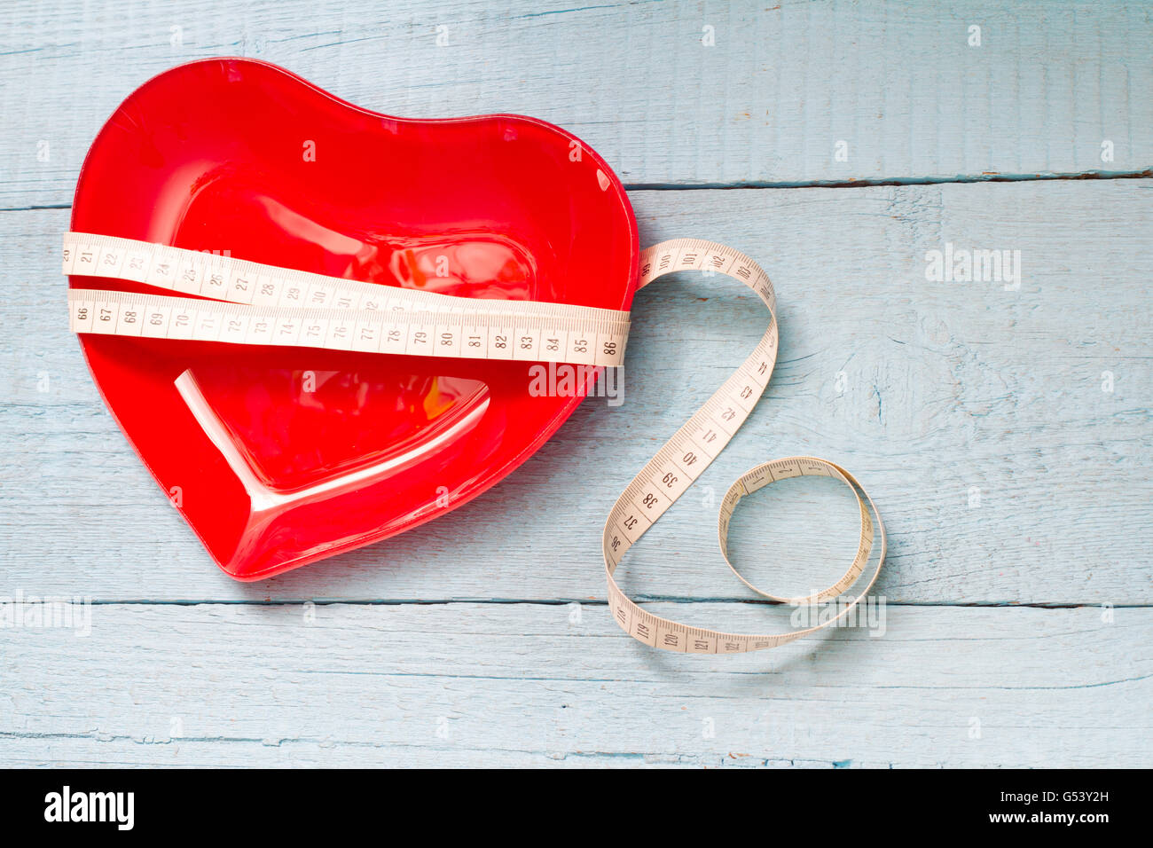 Passform und Gesundheit abstraktes Konzept mit roten Herzen Platte auf hölzernen blauem Hintergrund Stockfoto