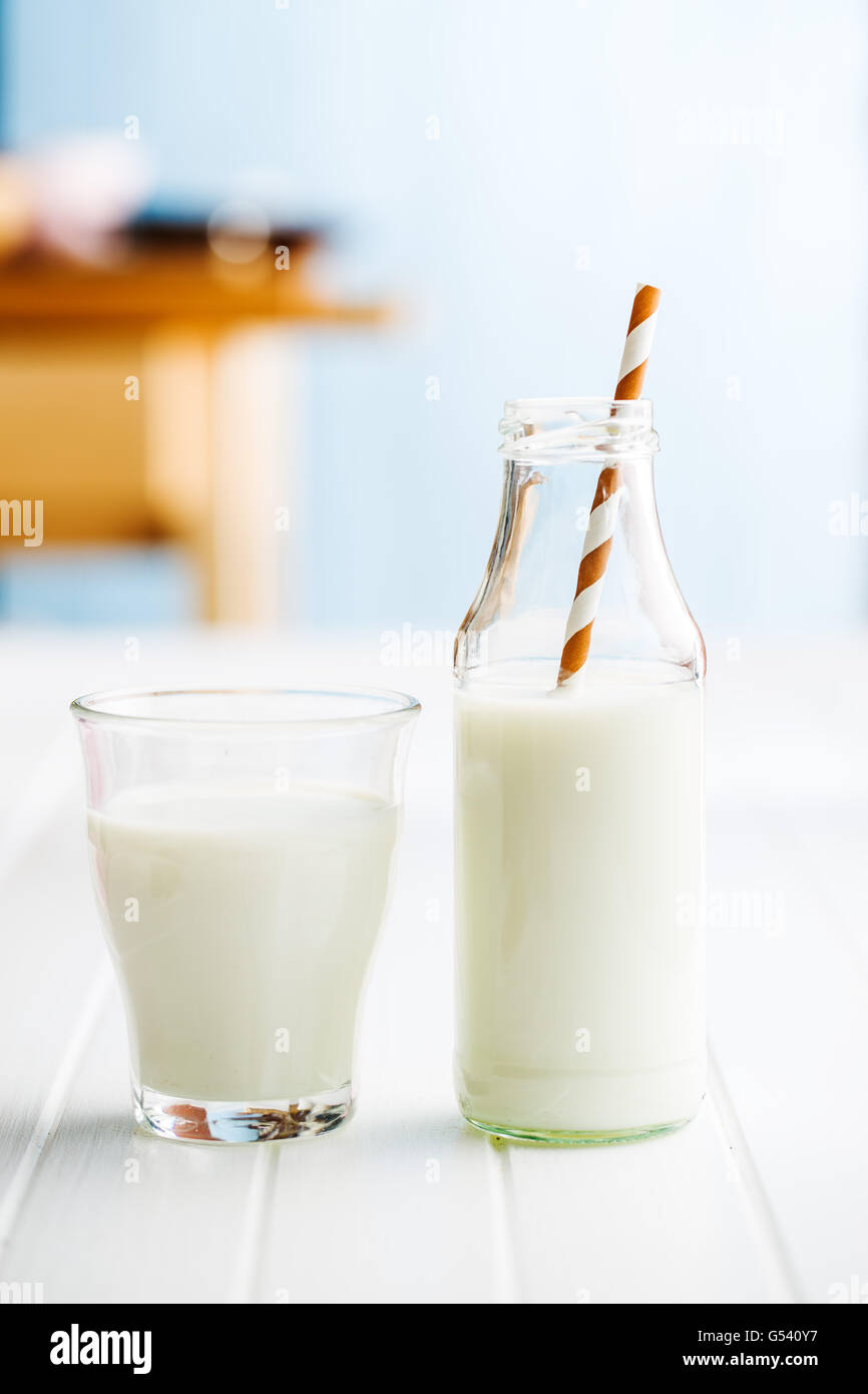 Frische Milch in Glasflasche mit Stroh. Stockfoto