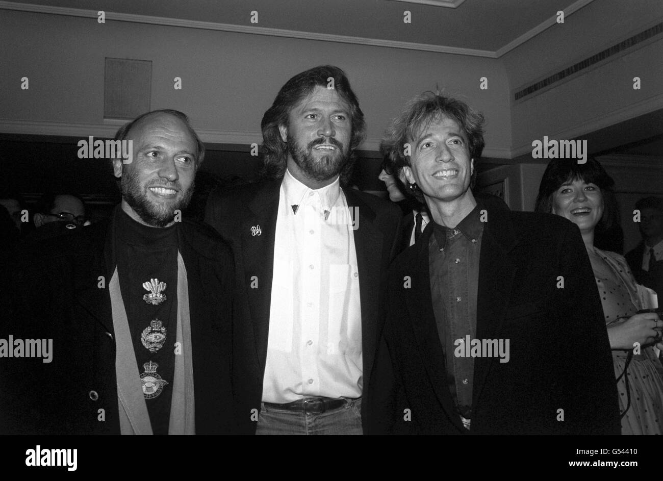 Die Bee Gees, von links nach rechts, die Brüder Maurice, Barry und Robin Gibb bei den Ivor Novello Awards im Londoner Grosvenor House Hotel, nachdem sie aus Amerika für die Zeremonie, die von den Songwritern, Komponisten und Autoren der British Academy veranstaltet wurde, eingeflogen waren. Stockfoto