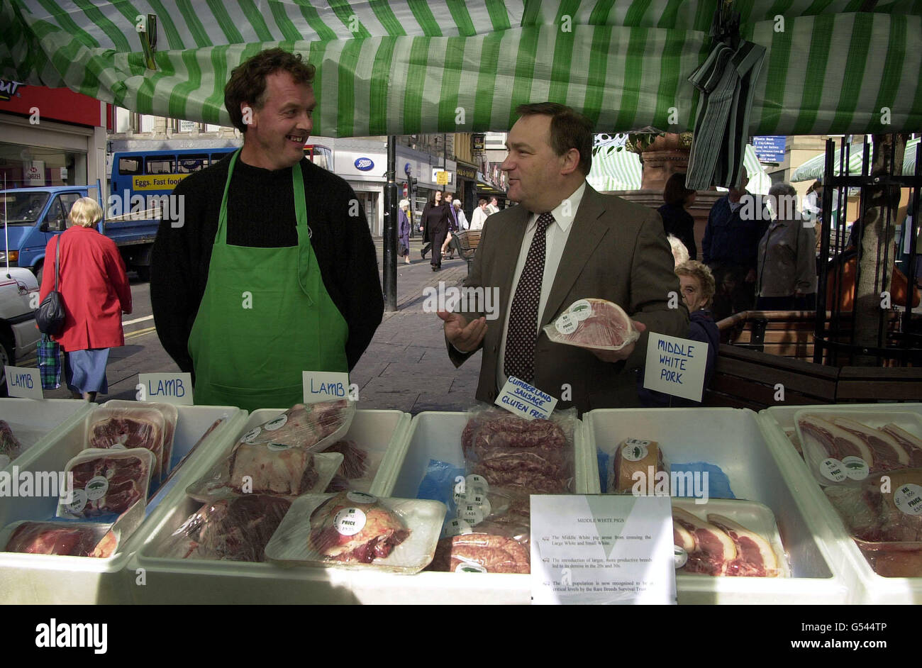 Landwirtschaftsminister Nick Brown (rechts) steht mit dem Landwirt und Standhalter Hugh Grey zusammen, als er den neuen Bauern- und Kreismarkt in Newcastle upon Tyne eröffnet. *zuvor gab er heute bekannt, dass die Regierung den Forderungen der Schweinezüchter nach Entschädigung nach dem Ausbruch der Schweinepest mehr als die Hälfte nachgekommen sei. Stockfoto