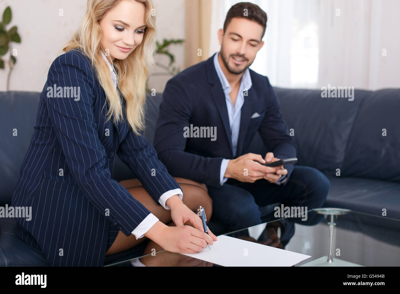 Geschäftsfrau und Geschäftsmann zu berechnen, auf Glasschreibtisch Stockfoto