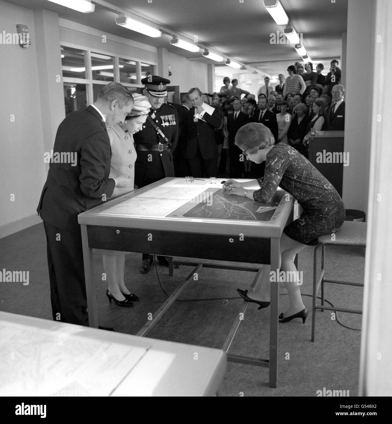 Königin Elizabeth II. (L.) beobachtet Jennie Johnson, wie sie auf Plastik „schreibt“, nachdem sie das neue Hauptquartier der Ordnance Survey in Southampton eröffnet hat. Stockfoto