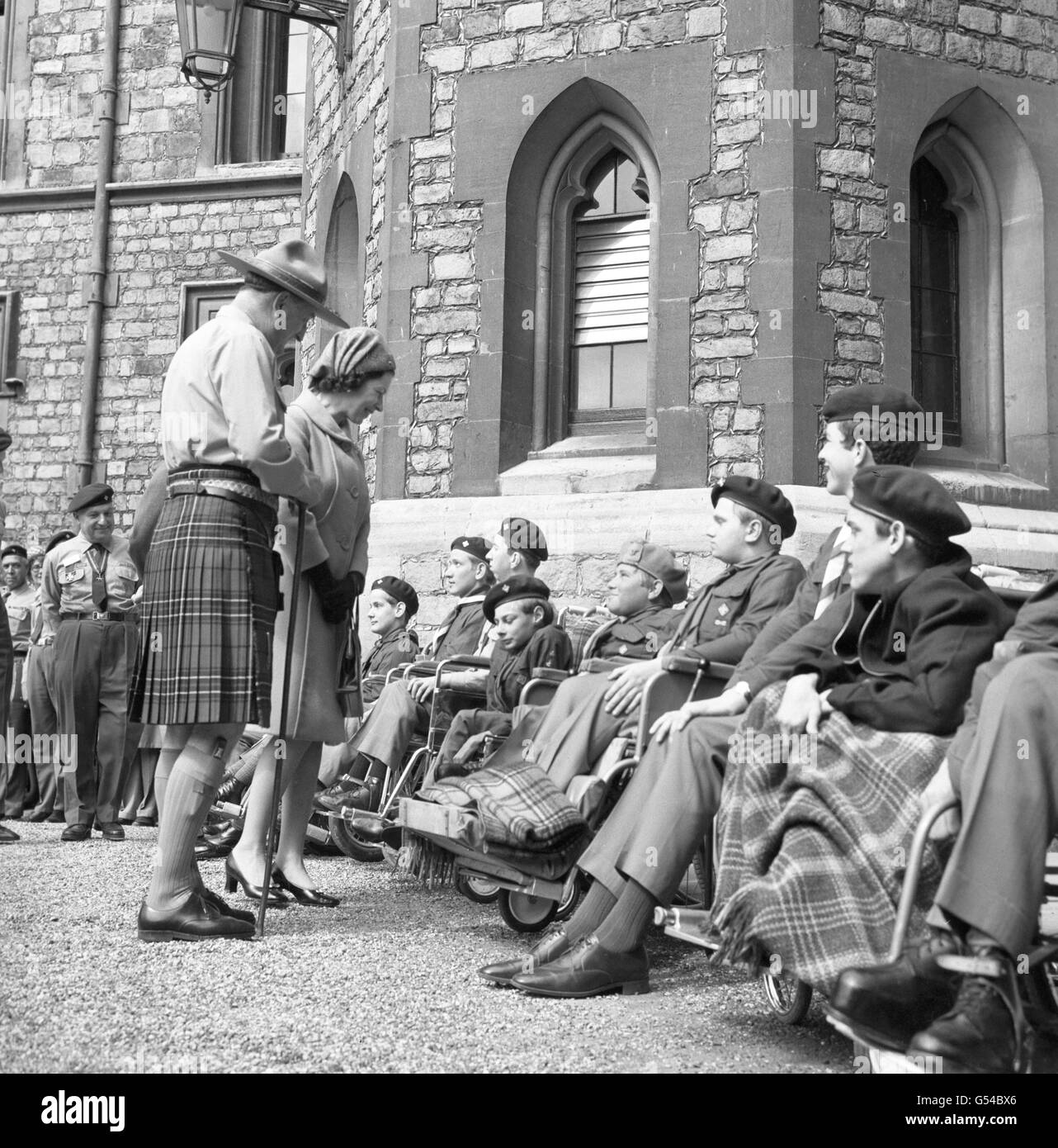 Königin Elizabeth II. Sprach mit dem 15-jährigen Jimmy Campbell, als sie während der jährlichen St. George's Day Parade der Queen's Scouts eine Gruppe von behinderten Pfadfinderinnen im Schloss Windsor traf. Stockfoto