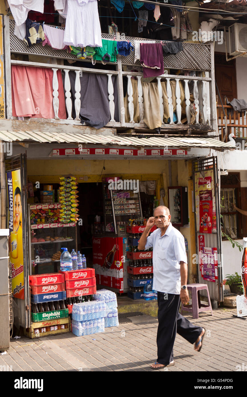 Sri Lanka, Galle Fort, Hausierer Street, Mann auf Handy, vorbei an kleinen Laden Stockfoto