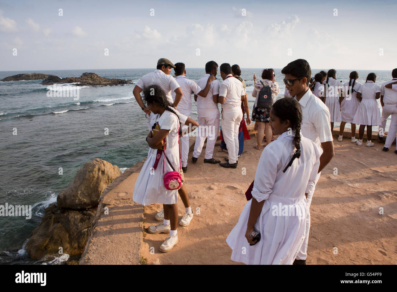Sri Lanka, Galle Fort, Gruppe von weiterführenden Schulkinder auf Flagge Felsen Burgwall mit Blick auf Meer Stockfoto