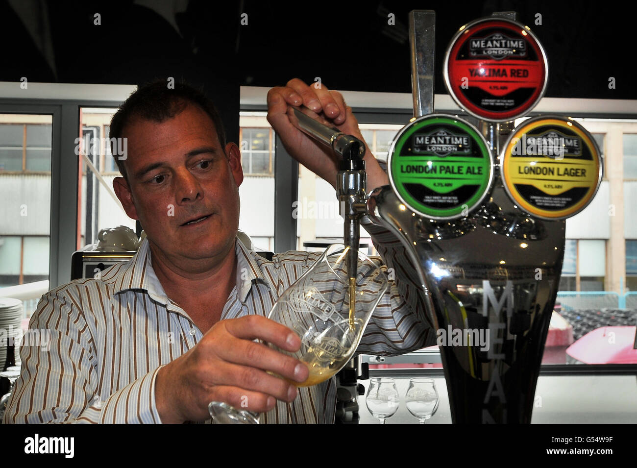 CEO Nick Miller zieht ein Bier in der Meantime Brewery in Greenwich. Stockfoto