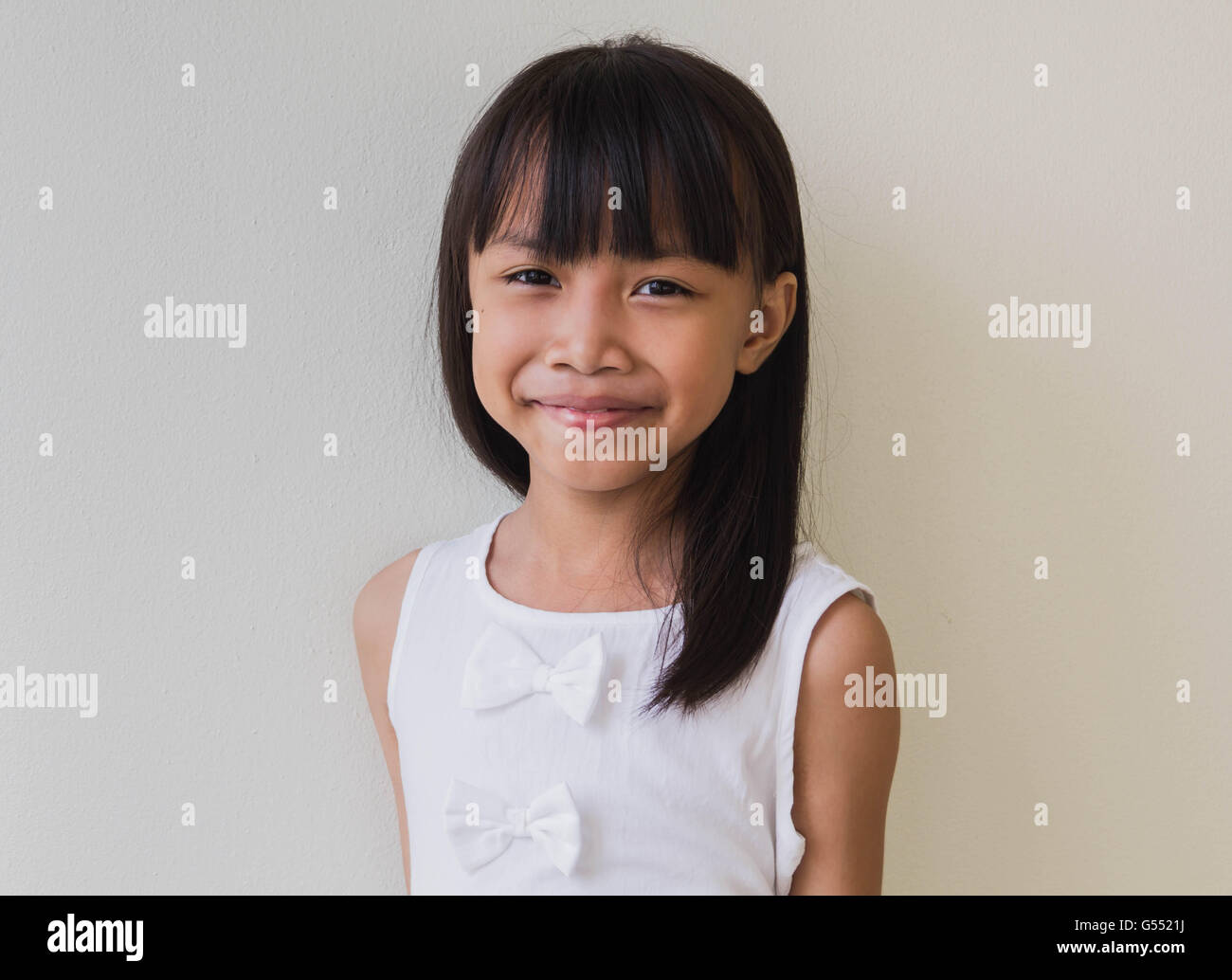 Glückliche kleine Asiatin isoliert in weiß Stockfoto