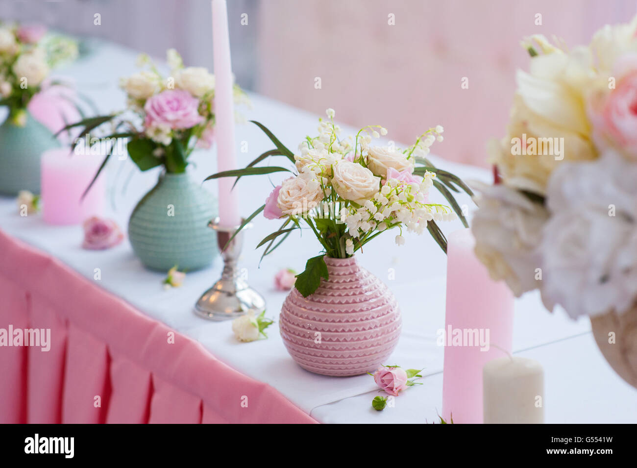 schöne Blumen in Vasen auf einer Hochzeitstafel Stockfoto