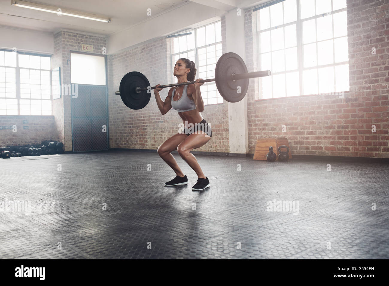 Weibliche Bodybuilder Übung mit einem schweren Gewicht Bar im Fitness-Studio. Voller Länge Aufnahme Fitness Frau Gewichtheben zu üben Stockfoto