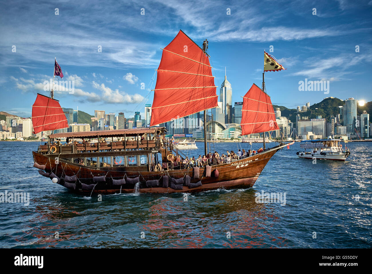 Die Aqua Luna Junk-nimmt Touristen auf einer Kreuzfahrt rund um Victoria Harbour in Hongkong. Stockfoto