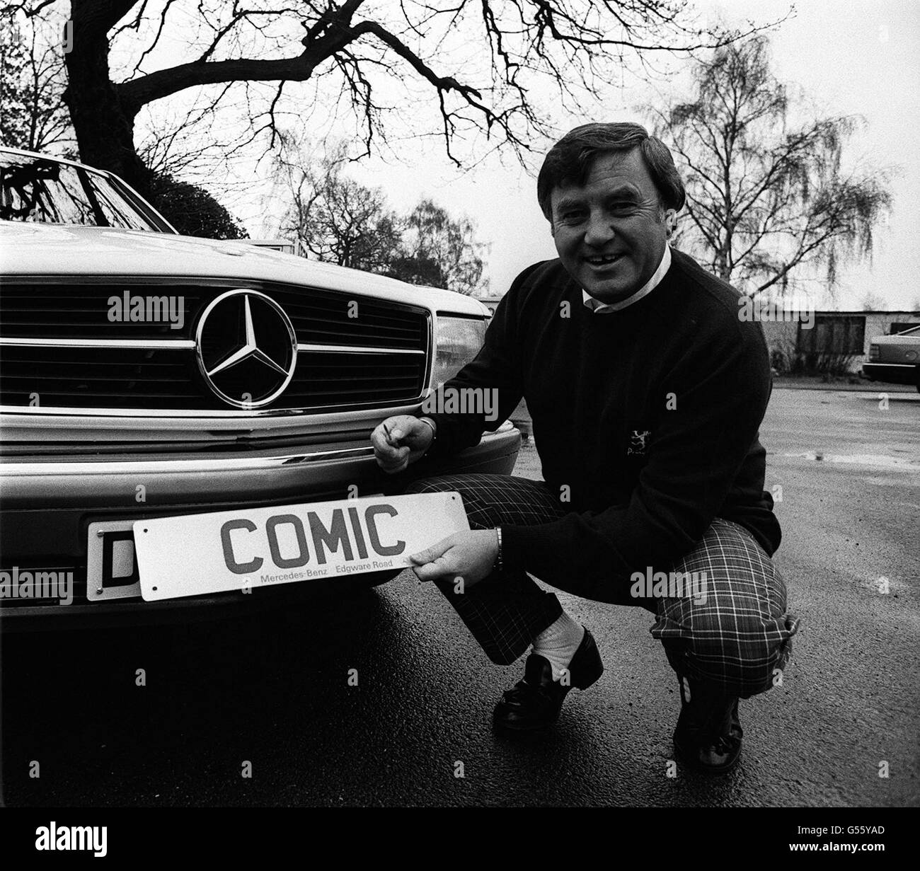 Komiker Jimmy Tarbuck. Der Komiker Jimmy Tarbuck mit seinem berühmten Nummernschild-Comic, den er auf seinen neuen Mercedes-Benz setzt. Stockfoto