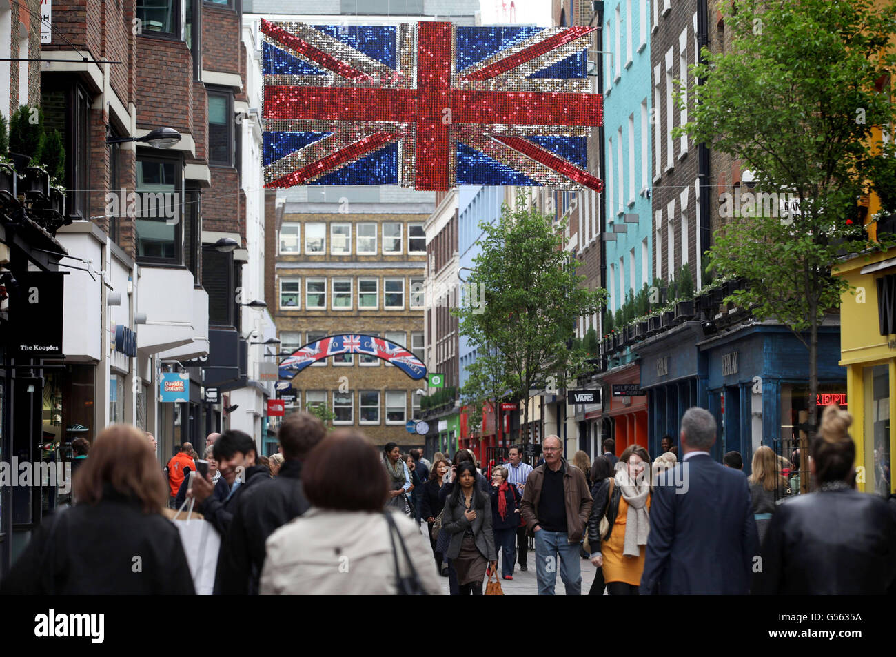 Über der Carnaby Street im Zentrum Londons hängt eine dekonstruierte, dreidimensionale Unionsflagge, die mit tausenden metallischen roten, weißen und blauen Schimmer-Scheiben bedeckt ist, als Teil der überdimensionalen öffentlichen Kunstinstallationen für das Diamond Jubilee. Stockfoto