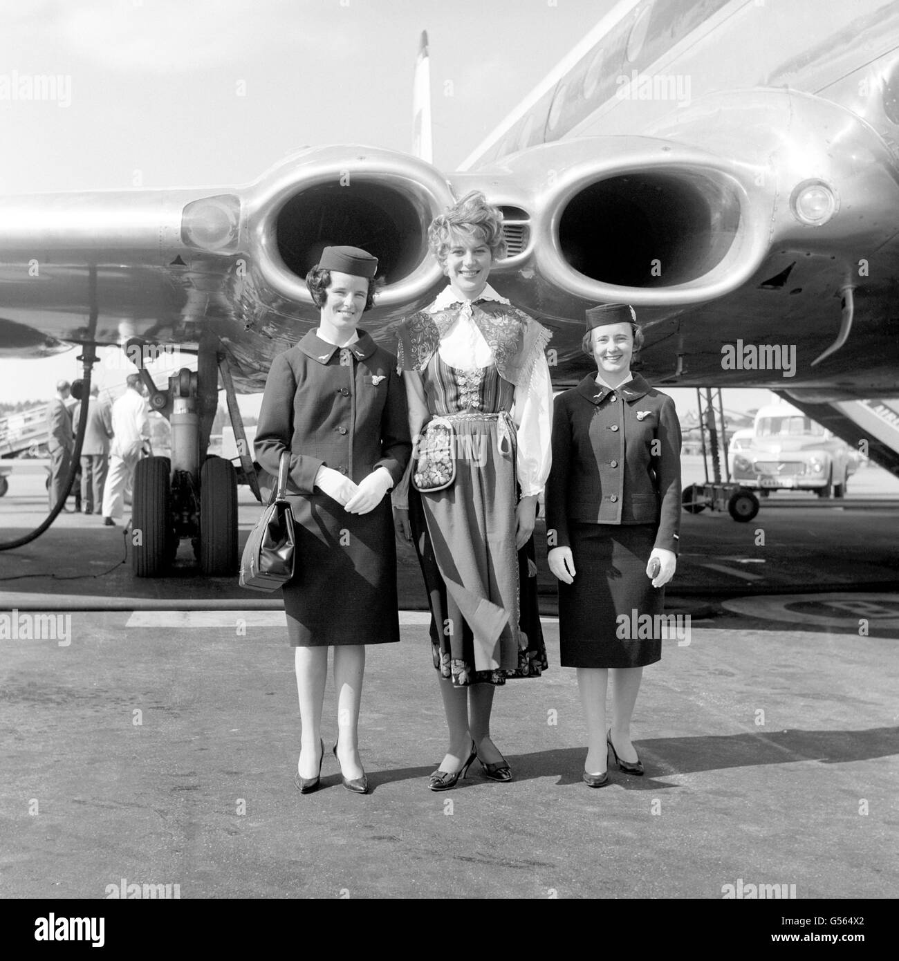 Die Stewardinnen Marie-Theresa Cantwell (l) und Victoria Annett (r) der britischen European Airways, mit Frau Siw Joenson, die in schwedischem Nationalkostüm auftrat, als sie sie am Flughafen Stockholm begrüßte, nachdem sie auf dem ersten Flug des Comet 4b-Dienstes aus London angekommen war. Stockfoto