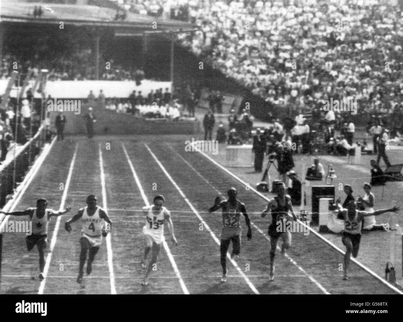 Jamaikas Keith Gardner (ganz rechts) taucht am Band ab, um das 100-Meter-Finale der Männer in einer Rekordzeit von 9.79 zu gewinnen. Tom Robinson von den Bahamas (Zweiter von links) wurde Zweiter, Mike Agostini aus Kanada (ganz links) wurde Dritter. Ebenfalls abgebildet sind Peter Radford aus England (13), Jimmy Omagbemi aus Nigeria (32) und Gordon Day (63) aus Südafrika. Stockfoto