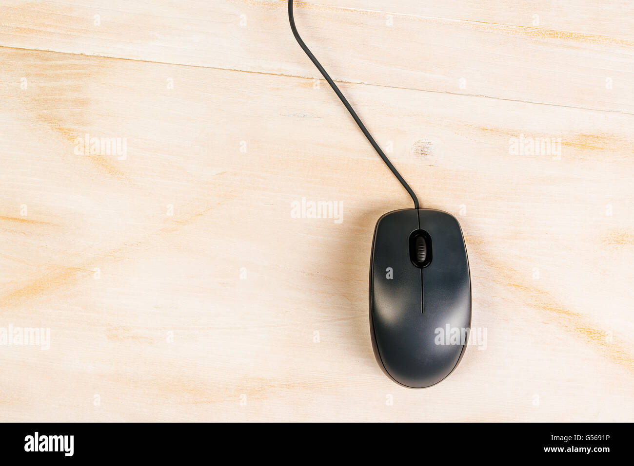 Computer-Maus mit Kabel auf Schreibtisch, Ansicht von oben Stockfoto