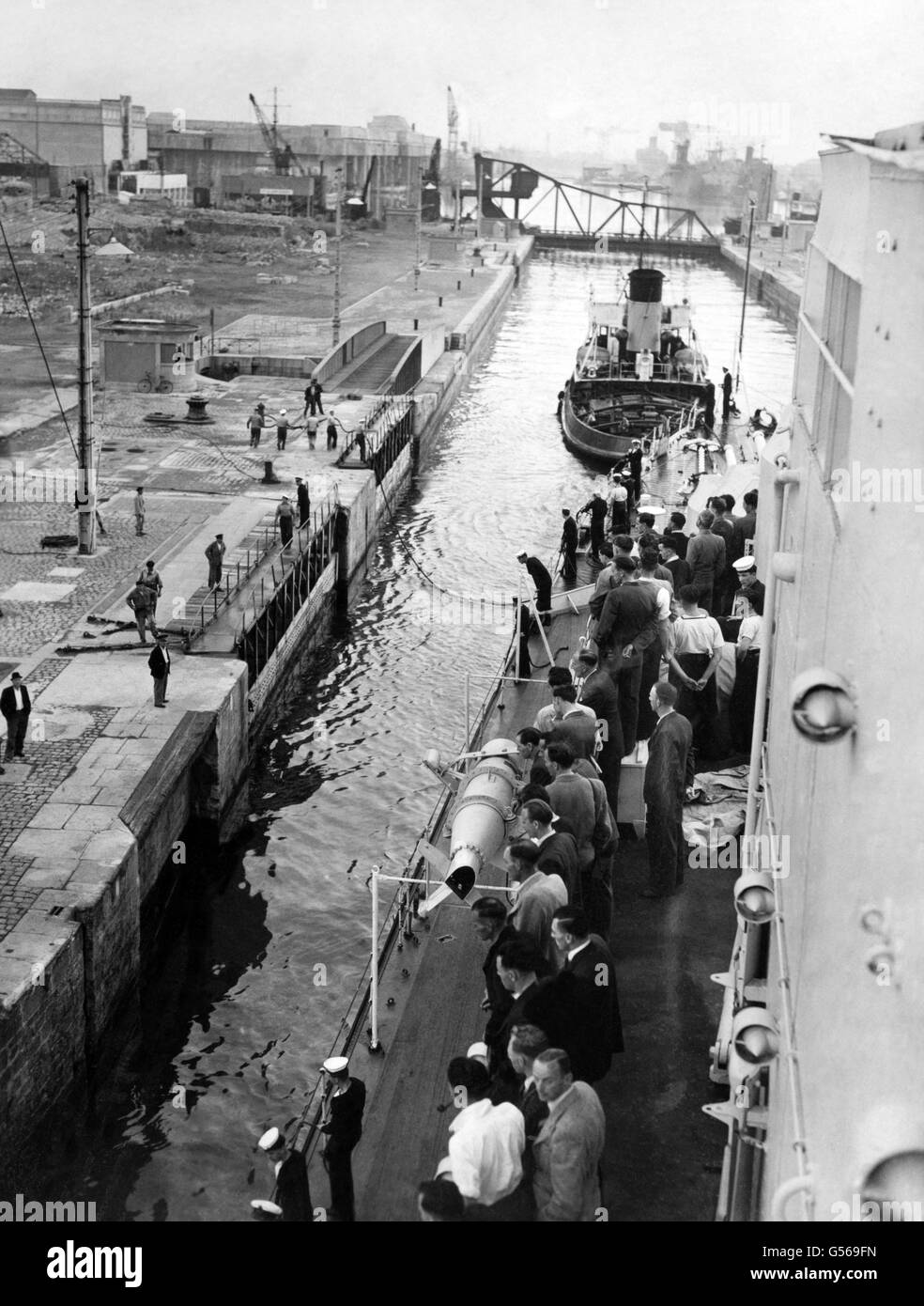 Ex-Commandos an Bord der HMS Sirius segeln in den Hafen von St. Nazaire, Frankreich. Sie waren Überlebende des Überfalls von St. Nazaire oder der Operation Chariot, eines erfolgreichen britischen Angriffs auf die stark verteidigte Normandie-Trockendock in St. Nazaire im deutsch besetzten Frankreich während des Zweiten Weltkriegs. Sie wurden von den Menschen der Stadt begrüßt, als sie mit einer Bronzetafel an Land marschierten, mit der Aufschrift "Sie haben viel erreicht, alles gewagt", für einen französisch vorbereiteten Monolith. Stockfoto