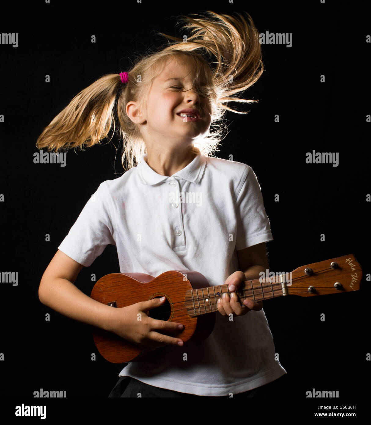 Humorvolle Studio-Porträt eines jungen Mädchens, singen und spielen der Ukulele. Stockfoto