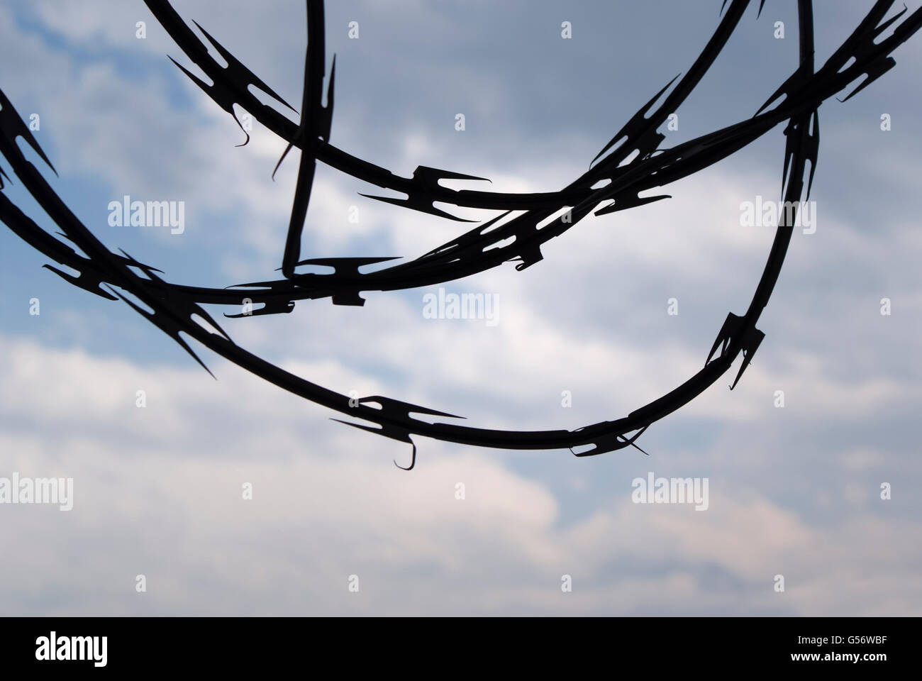 Foto von einer blauen hellen Wolkenhimmel mit Barb Wire silhouette Stockfoto