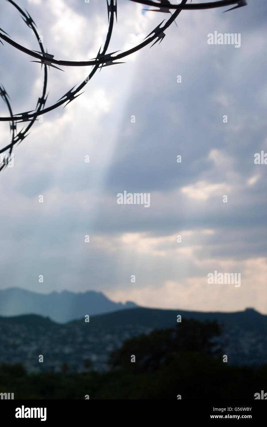 Foto von hell blau bewölktem Himmel mit Barb Wire silhouette Stockfoto