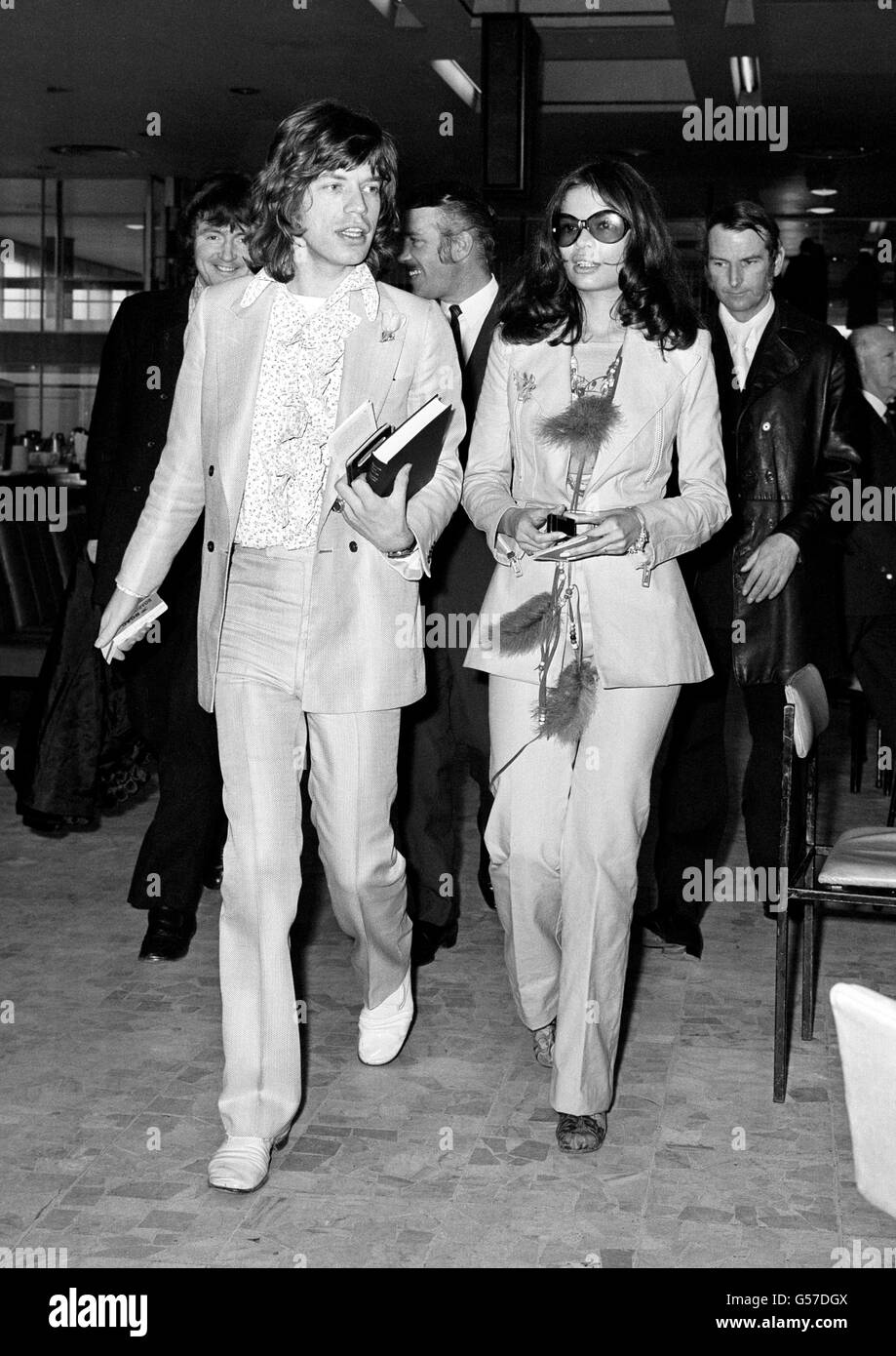 MICK + BIANCA JAGGER 1970: Rolling Stone-Mitglied Mick Jagger verlässt Heathrow für einen 2-wöchigen Urlaub in Nassau, Bahamas. Mit ihm ist Frau Bianca Pereze Morena de Macias, eine 21-jährige Nicaraguanerin. Die Zeitung France Soir berichtete heute (14. April 1971), dass das Paar heiraten soll. Stockfoto