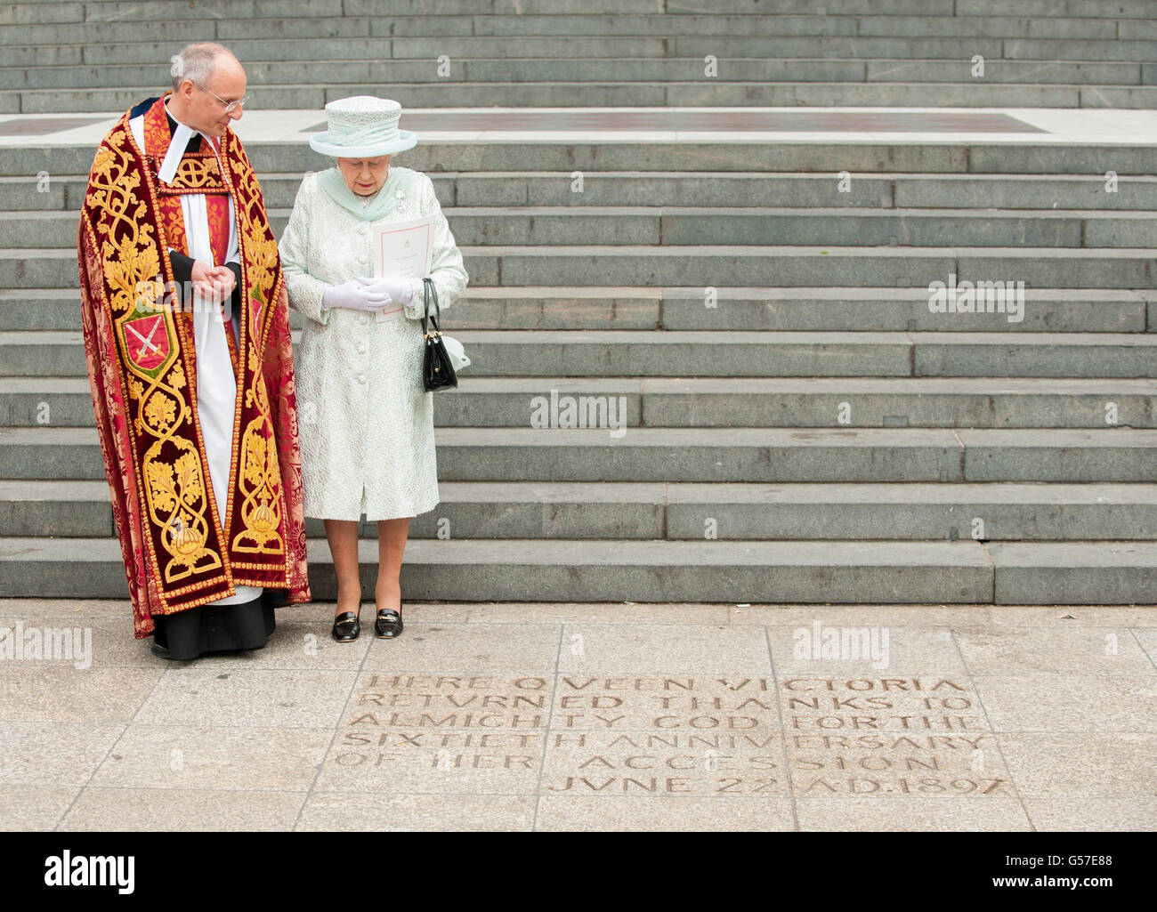 Königin Elizabeth II. Sieht eine Inschrift am Fuße der Stufen der St. Paul's Cathedral im Zentrum von London, zusammen mit Dean von St. Pauls, Dr. David Ison, nach einem Dankgottesdienst. Stockfoto