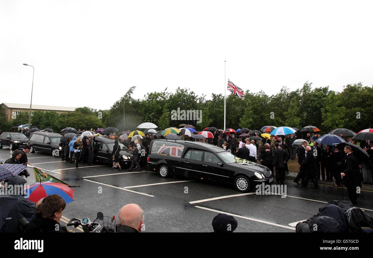 Freunde und Familie schließen sich Trauernden an, um Blumen zu legen, wie die Särge des privaten Gregg Thomas Stone vom 3. Bataillon, des Yorkshire Regiment (rechts) und des CPL Michael John Thacker vom 1. Batalion, des Royal Welsh (der Royal Welsh Fusiliers), am Memorial Garden in Carterton, in der Nähe von RAF Brize Norton, Oxfordshire, vorbeikommen. Stockfoto