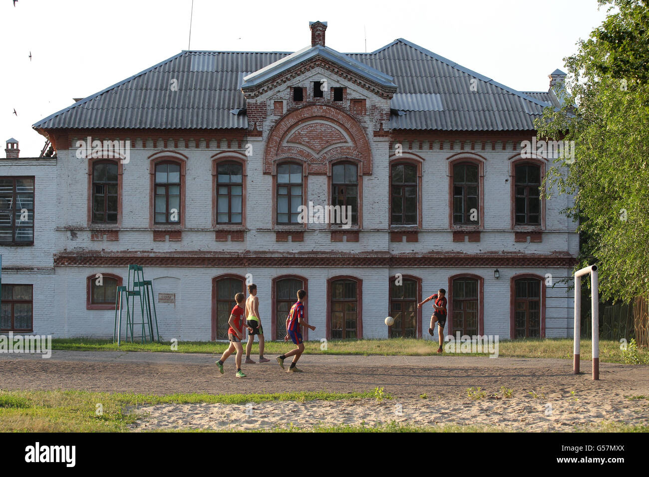 16-Jährige der High School in Izyum spielen nach der Schule auf dem Schulfußballplatz. Stockfoto