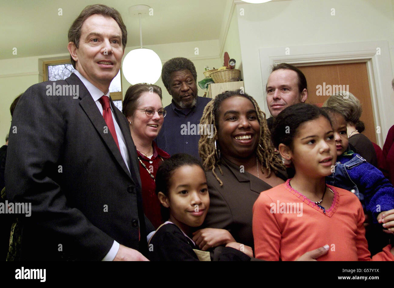 Der britische Premierminister Tony Blair (L) posiert mit Eltern und adoptierten Kindern im Coram-Familienzentrum in London. Herr Blair hat sich persönlich für die Neuannahme des Vorsitzes eines Kabinettsausschusses interessiert, der zur Einführung neuer Gesetze geführt hat. Stockfoto