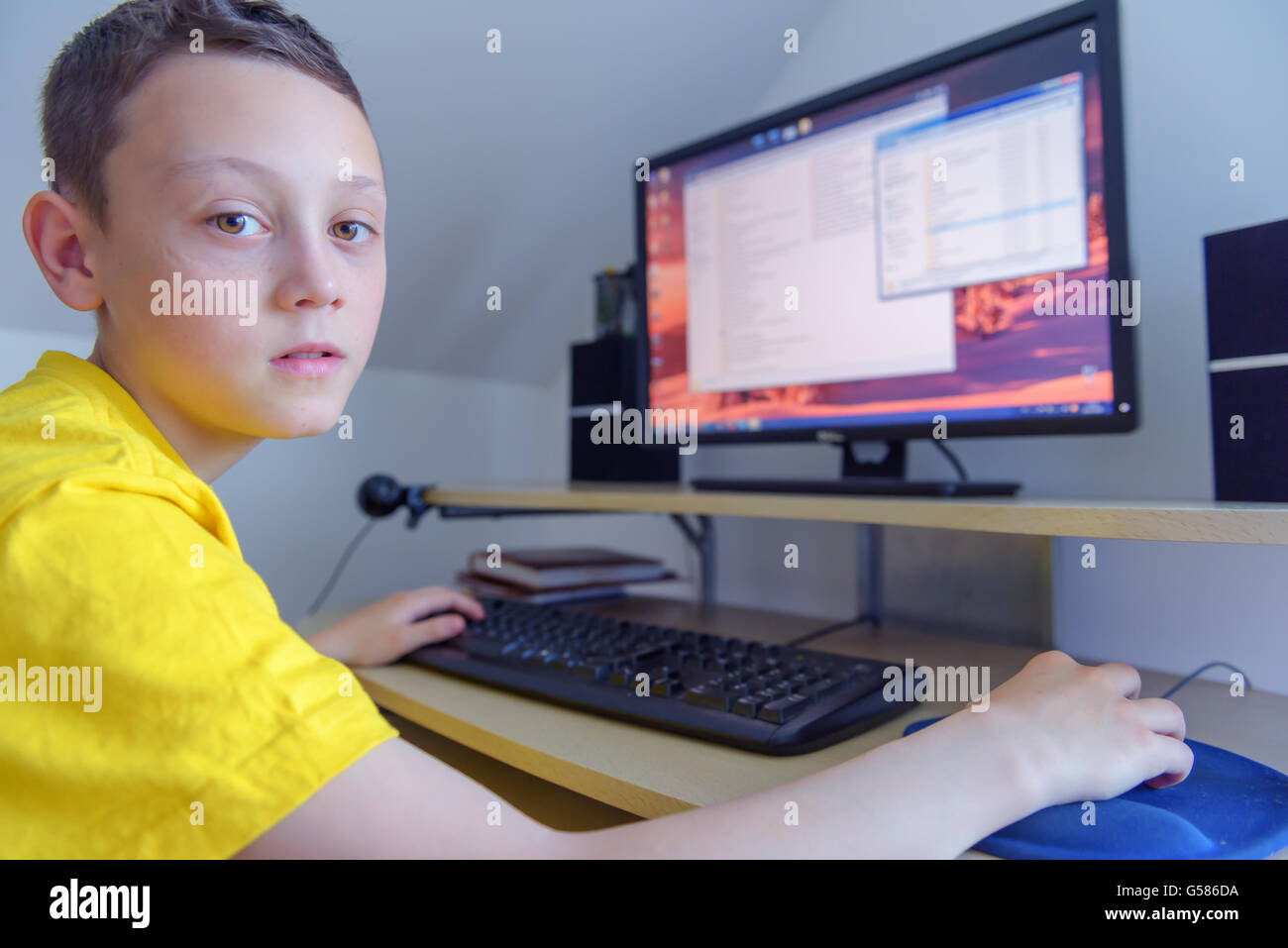 Jungen arbeiten am Computer in seinem Zimmer Stockfoto