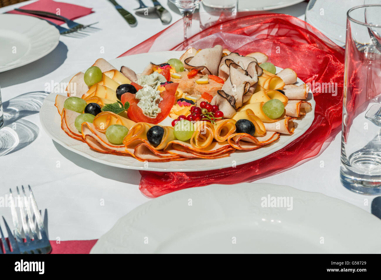 Kalte Platte mit Schinken, Käse und Obst. Gedeckten Tisch weiß- und Rotwein im Garten Stockfoto