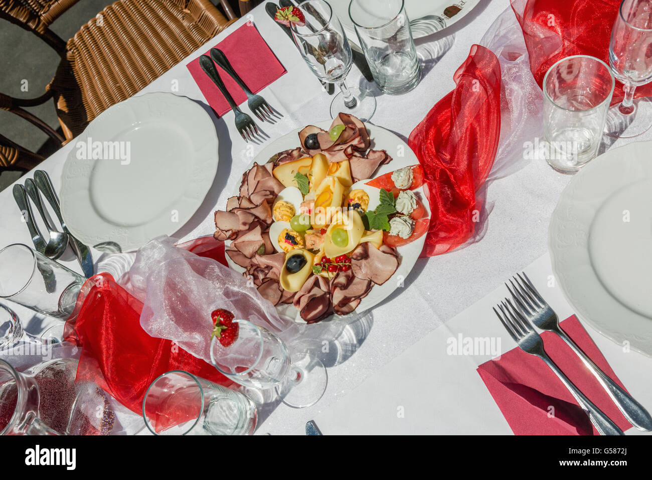 Kalte Platte mit Schinken, Käse und Obst. Gedeckten Tisch weiß- und Rotwein im Garten Stockfoto