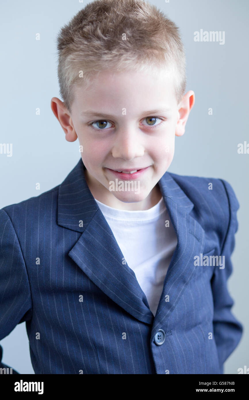 Porträt eines jungen Mannes trägt einen Anzug Blazer und Lächeln für die Kamera. Er von der Taille, auf einem weißen Zeitmessung zu sehen Stockfoto