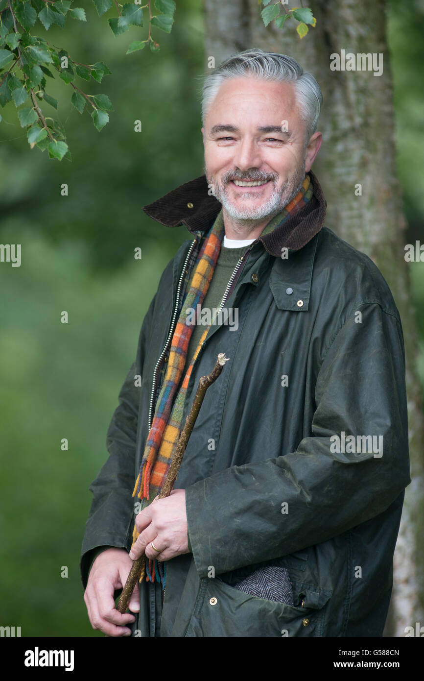 Porträt eines Bauern in einem Feld. Er hält einen Stock und Lächeln für die Kamera. Stockfoto
