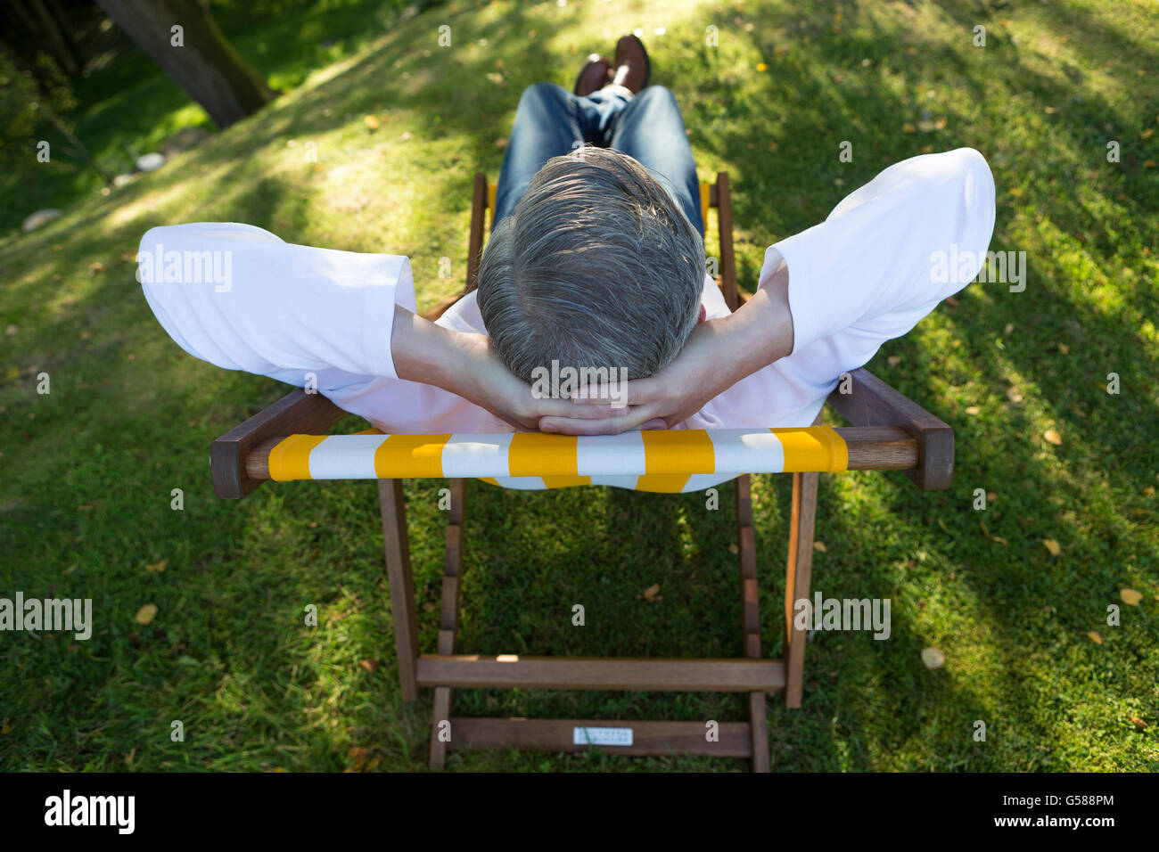 Ariel Ansicht eines reifen Mannes entspannen auf dem Liegestuhl in seinem Garten Stockfoto