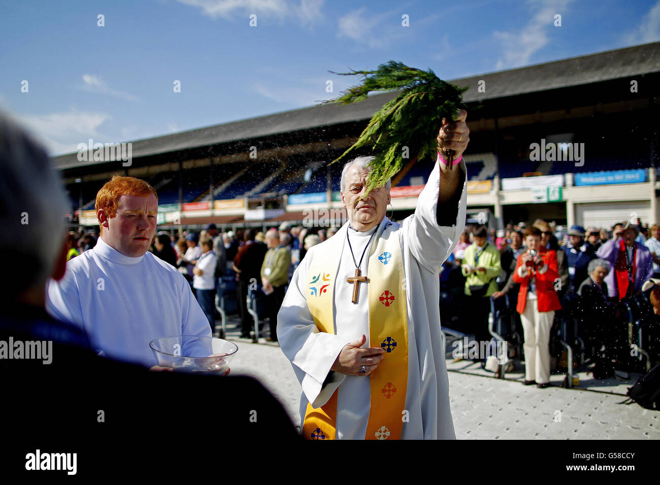 Church of Ireland der Erzbischof von Dublin Michael Jackson besprüht die Pilger während des 5. Eucharistischen Kongresses, der die ganze Woche im RDS in Dublin stattfindet, bei der Freiluftmesse in der Hauptarena mit heiligem Wasser. Stockfoto