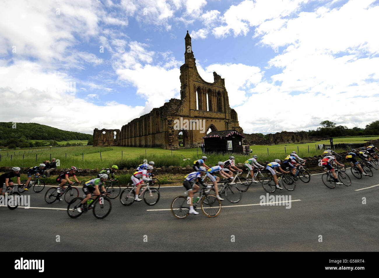 Fahrer fahren bei den Men's Road Race Road Race National Championships in Ampleforth, Yorkshire, an Byland Abbey nahe Coxwold vorbei. Stockfoto