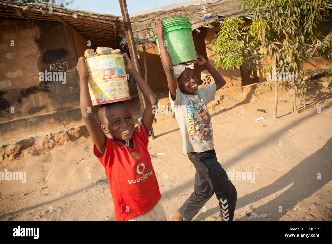 Kinder tragen Wasser in einem Vorort in Nampula, Mosambik. Stockfoto