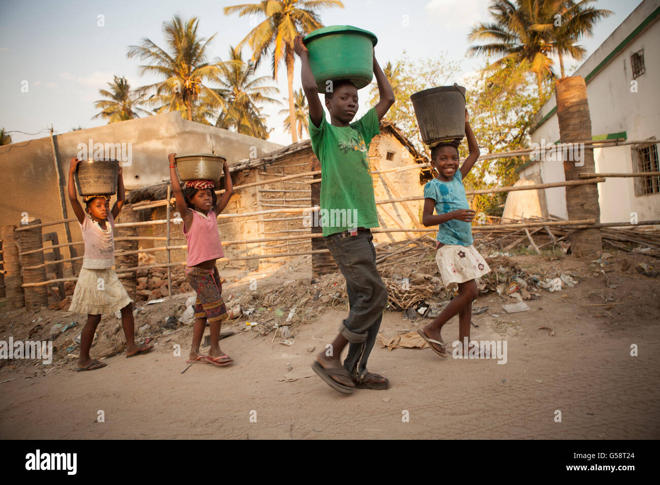 Kinder tragen Wasser in einem Vorort in Nampula, Mosambik. Stockfoto