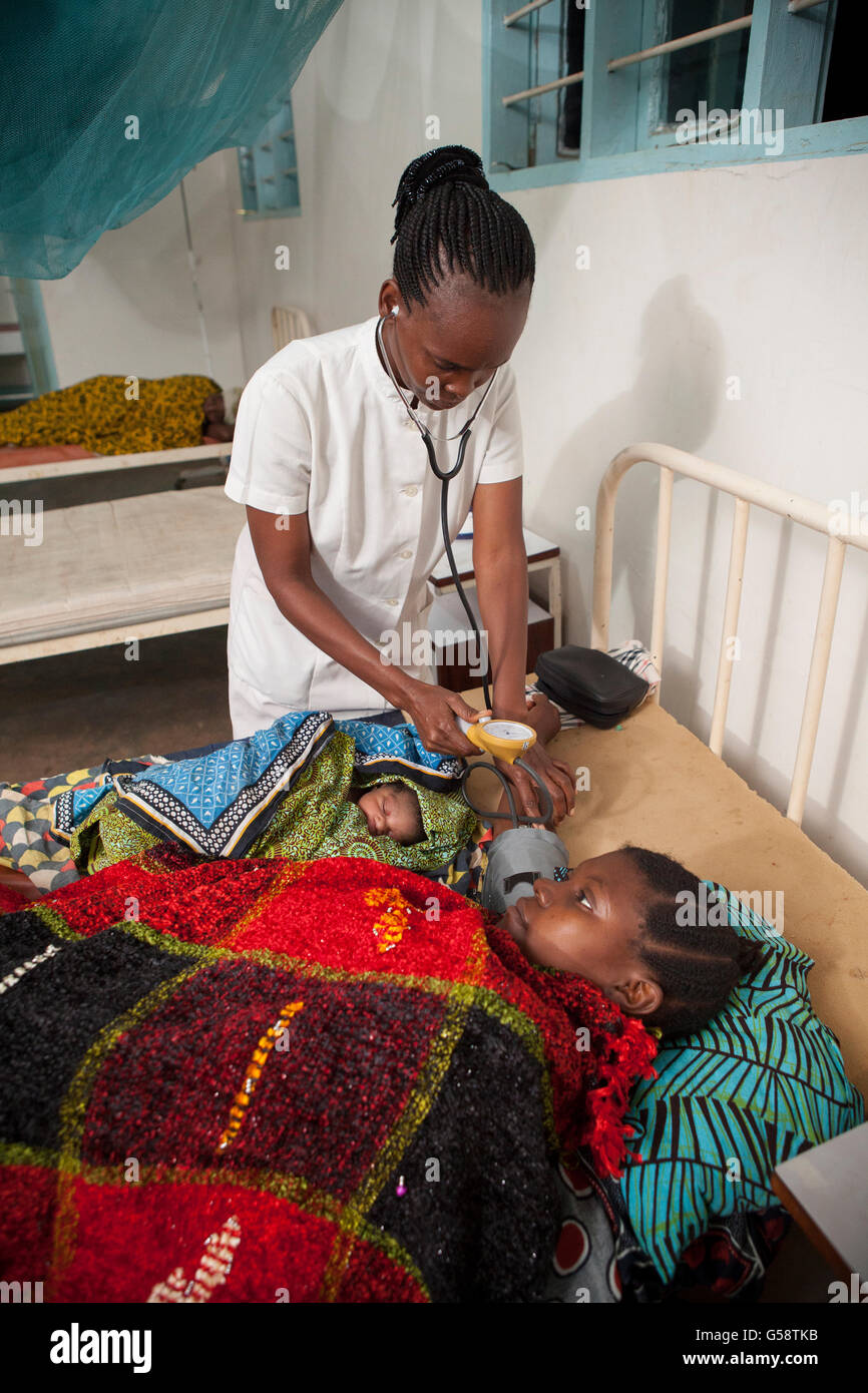 Eine Krankenschwester kümmert sich um ihr neugeborenes Baby in Kigoma Region, Tansania und Patienten. Stockfoto